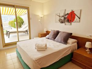 a bedroom with a large bed and a balcony at Apartment Luna Tossa De Mar 5mins walking to the beach with sea and castle view big terrace in Tossa de Mar