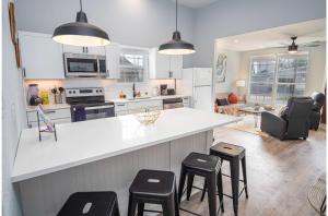 una cocina con encimera blanca y taburetes en Charming 3BR2BA Gem Close to Downtown Riverwalk, en San Antonio
