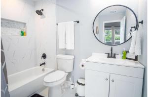 Baño blanco con lavabo y espejo en Charming 3BR2BA Gem Close to Downtown Riverwalk, en San Antonio 25 fotos más