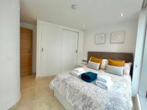 a bedroom with a bed with towels on it at Luxury 1 Bed - City Suites Ocean Spa Plaza in Gibraltar