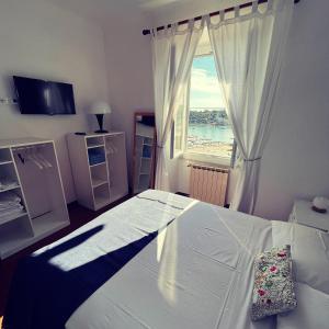 een slaapkamer met een bed en een groot raam bij Casa Le Grazie V Battisti nr 141 Portovenere in Le Grazie