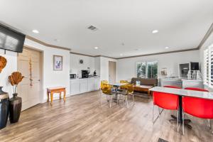 a kitchen and living room with red chairs and a table at Executive Inn & Suites Magnolia in Magnolia