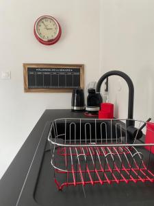a dish rack on a kitchen sink with a clock at Nid douillet à La Bresse in La Bresse