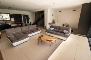 uma sala de estar com dois sofás e uma mesa de centro em SUD VILLA DE LUXE - PLAGES - PISCINE - JACUZZI - Jeux Olympiques 2024 em Lattes