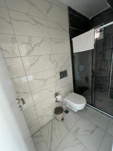 a white bathroom with a shower and a toilet at Airport Black Sea Hotel in Arnavutköy