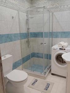 a bathroom with a shower and a washing machine at Cozy Kremasti Apartment in Kremasti