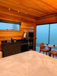 um quarto com uma cama, uma cozinha e uma mesa em Refúgio de Altitude - Centro em Urupema