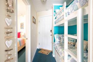 Cette chambre pour enfants dispose de murs bleus et de lits superposés. dans l'établissement GypSEA Blu Beach Condo Steps to the Beach, à Galveston