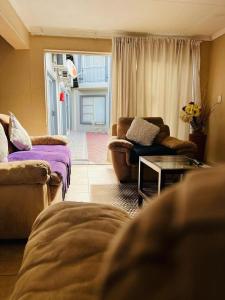 sala de estar con sofá y mesa en Zamambongi Guest House, en Newcastle