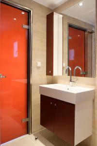ein Bad mit einem Waschbecken und einer roten Tür in der Unterkunft Aeon Retreat in Rovies