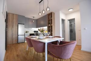 een keuken en eetkamer met een witte tafel en paarse stoelen bij Garden apartment Leoma with free parking! in Zadar