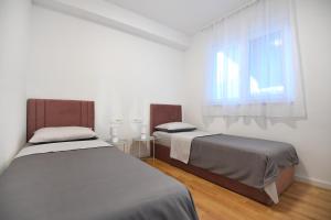 een slaapkamer met 2 bedden en een raam bij Garden apartment Leoma with free parking! in Zadar