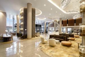 a lobby of a building with couches and chairs at Radisson Blu Hotel Riyadh Convention and Exhibition Center in Riyadh