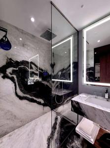 a bathroom with a shower and a sink at Radisson Blu Aurum Hotel, Brasov in Braşov