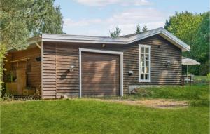a small brown house with a large garage at Stunning Home In Fårevejle With Wifi in Fårevejle