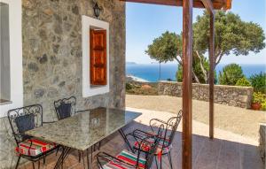 Agia ParaskeviにあるAmazing Home In Agios Vasilios With Wifiの海の景色を望むパティオ(テーブル、椅子付)