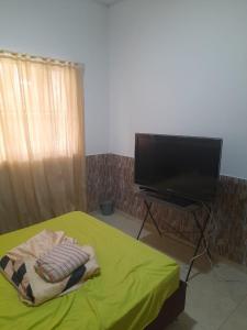 - une chambre avec un lit et une télévision à écran plat dans l'établissement Villa Laura Togui Boyaca, à Togüí