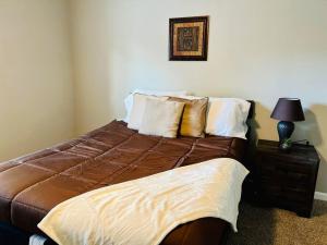 1 dormitorio con cama y mesita de noche con lámpara en Modern Gem: 2BD/2BA Oasis in Shadowbriar, Houston!, en Houston