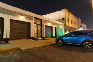 a blue suv parked in front of a house at night at شاليهات ريفي in Riyadh