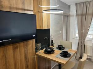MISIC HOME في كولمار: طاولة طعام مع تلفزيون بشاشة مسطحة في الغرفة
