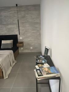 MISIC HOME في كولمار: غرفة نوم بسرير وطاولة مع مجله