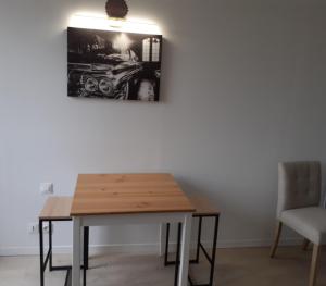 a table and chairs in a room with a picture on the wall at studio in Aulnoye-Aymeries