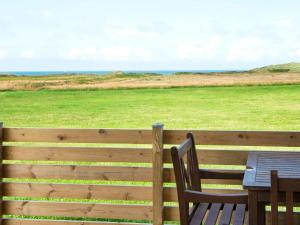 Transにある6 person holiday home in Lemvigの田園の景色を望む柵の上にテーブルと椅子