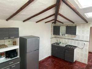una cocina con nevera de acero inoxidable y armarios negros en Casa campestre Ubate, en Ubaté