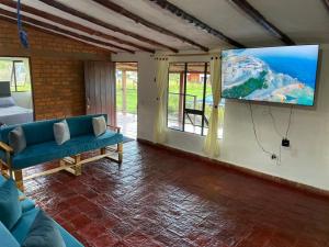 sala de estar con sofá y TV de pantalla plana en Casa campestre Ubate, en Ubaté