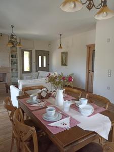 een woonkamer met een houten tafel met bloemen erop bij Seaside retreat house in Paralía Sergoúlas