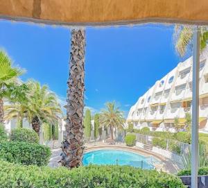 a view of the pool from the balcony of a resort at Le soupir des palmiers. Idéal couple, piscine, mer in La Grande-Motte +16 photos