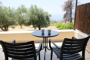 two chairs and a table with two cups on a balcony at Aeon Retreat in Rovies