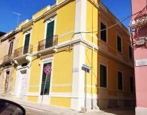 a yellow and white building on a street at B&B IMMARE in Brindisi