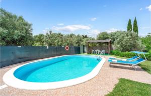 a swimming pool with a table and a chair next to it at I Cipressi in Bibbona