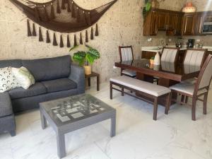 a living room with a couch and a table and chairs at Ancla Suite 2 - 2 Bedroom Urban Hotel in Puerto Peñasco