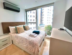a bedroom with a bed with a large window at Luxury 1 Bed - City Suites Ocean Spa Plaza in Gibraltar