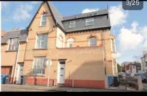 a large brick house with a black roof at Paradise Street Apartment 2 Bed Ground Floor in Rhyl