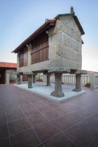 un edificio con una estructura de piedra en un patio en Casa Angelita terraza con hórreo y barbacoa en Poio