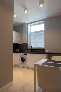 a kitchen with a washing machine and a window at Ostróda City Center PKO lake apartments balcony in Ostróda