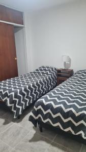 dwa łóżka siedzące obok siebie w pokoju w obiekcie Departamento cómodo w mieście La Rioja