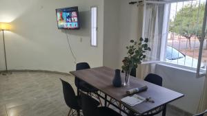 a dining room table and chairs with a table and a window at Departamento cómodo in La Rioja