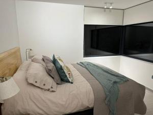 ein Schlafzimmer mit einem Bett mit Kissen darauf in der Unterkunft Apartamento Nuevo Pucón in Pucón