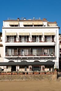 un edificio blanco con balcones y plantas. en Hotel Capri en Tossa de Mar