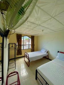 a room with two beds and a ceiling at Hotel Los Balcones in Tocaima