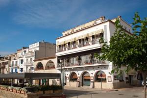 un edificio blanco con balcones en una calle en Hotel Capri en Tossa de Mar
