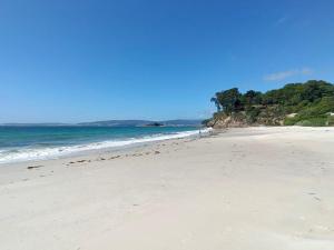 a sandy beach with the ocean in the background at El Mirador de playa LAPAMAN - BUEU in Marín