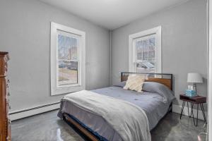 a bedroom with a bed and two windows at Navarre Apartments in Des Moines