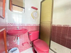 Baño rosa con aseo rosa y lavabo en Ayenda Alfay Mosquera, en Mosquera
