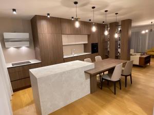 Gega Apartments في Gjakove: مطبخ وغرفة طعام مع طاولة وكراسي