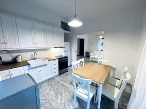 eine Küche mit einem Holztisch und weißen Schränken in der Unterkunft Orange Blossom Villa in Nafpaktos